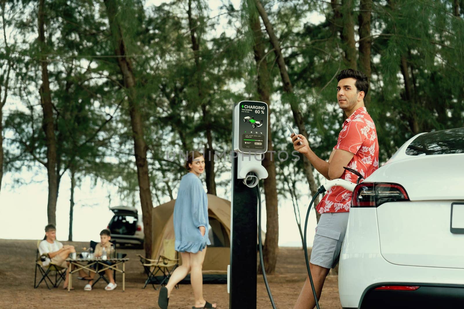 Lovely sit on trunk, charging EV car with EV charging station. Perpetual by biancoblue