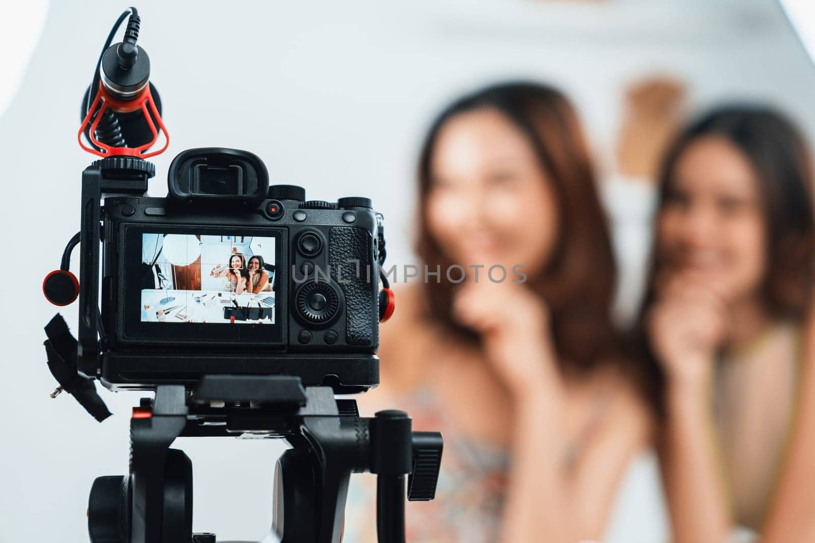 Asian Woman influencer shoot live streaming vlog video review makeup uttermost social media or blog. Happy young girl with cosmetics studio lighting for marketing recording session broadcasting online