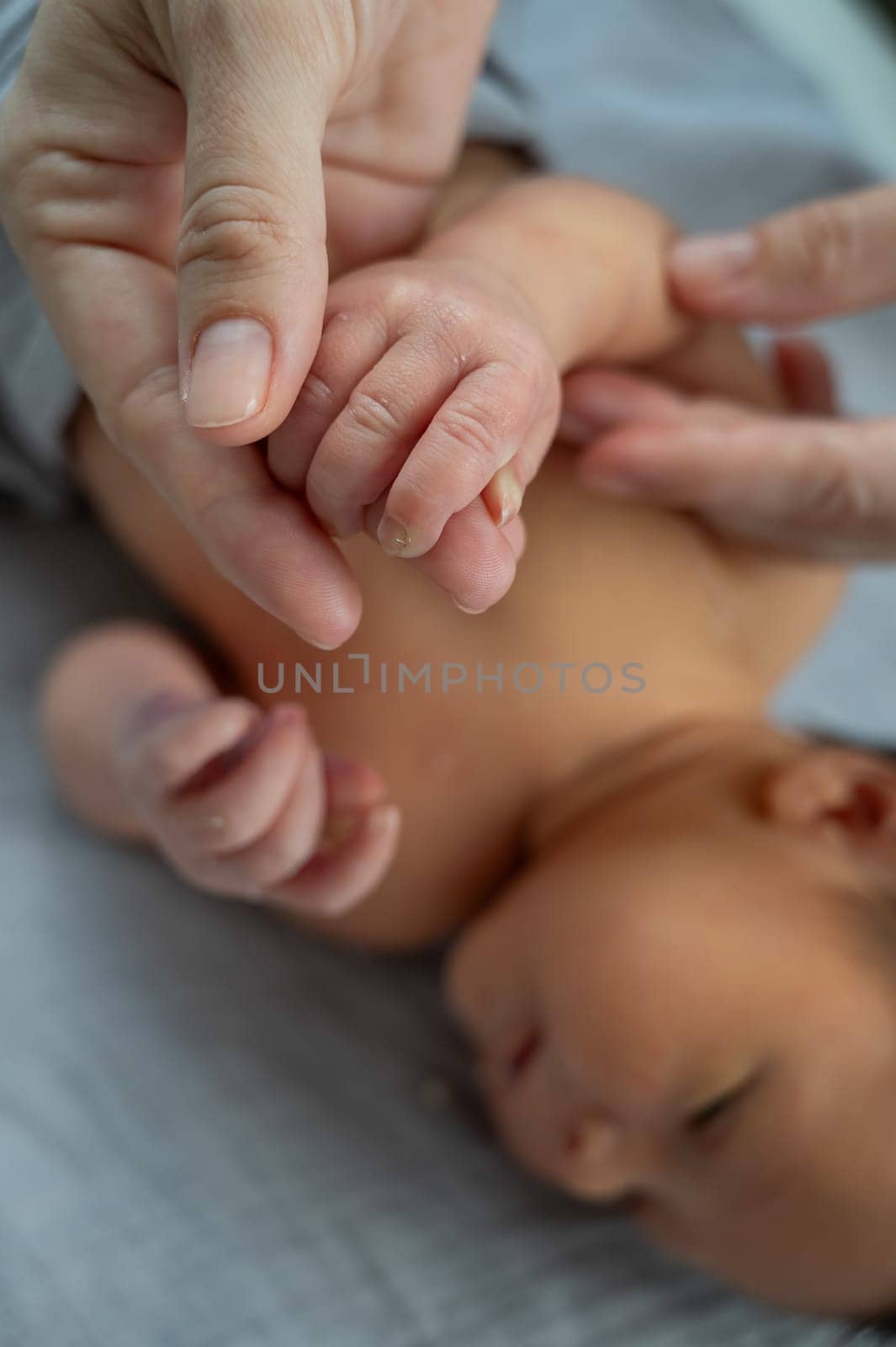 A newborn boy holds his mother's finger. Close-up of hands. by mrwed54