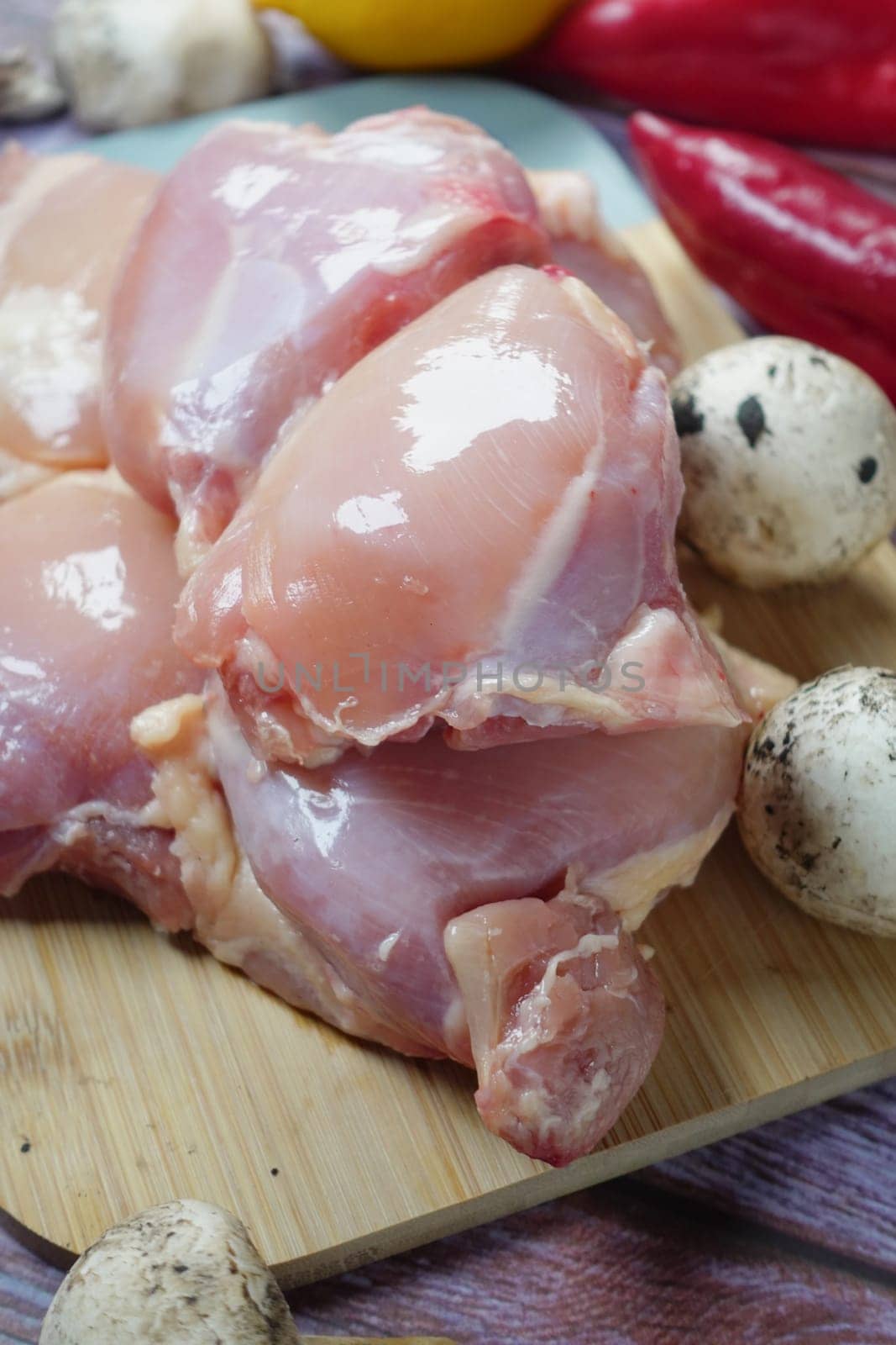 raw breast chicken meat and vegetables on table .