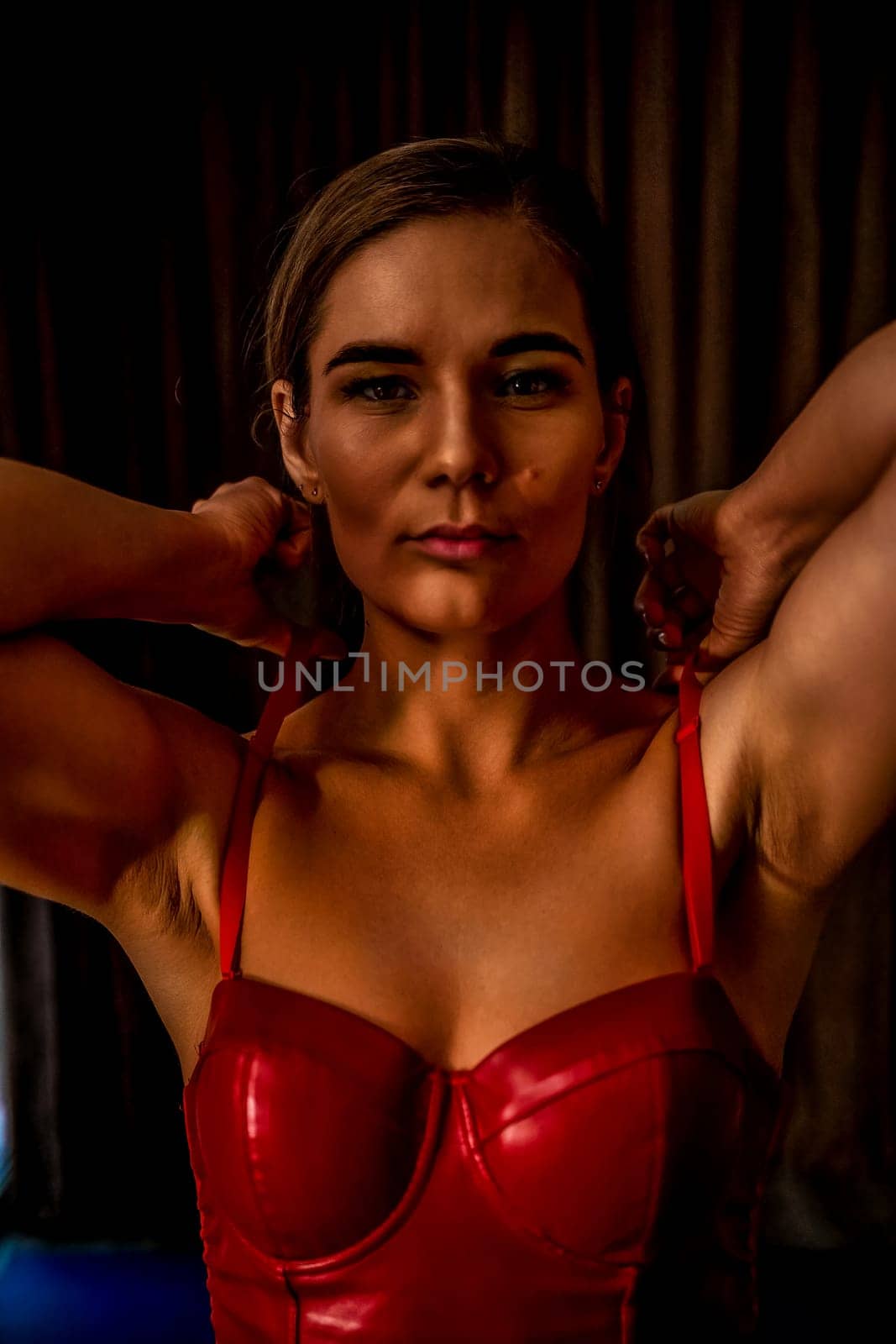 Party girl portrait. Young woman in red corset and black leather pants. Sexy seductive brunette in red and black costume. Role play. Celebration and party. Having fun. by panophotograph