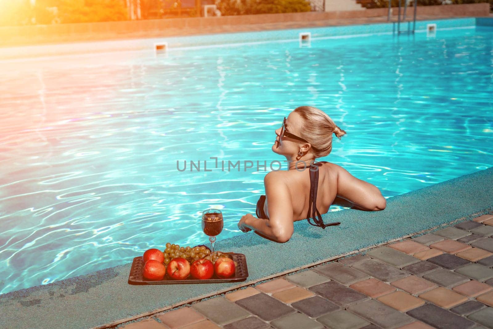 Bikini-clad woman enjoys poolside relaxation. Poolside ambiance. Capturing woman's relaxed time near pool. by Matiunina