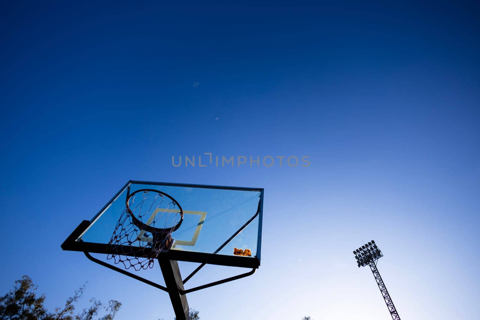 Basketball hoop in the public arena on a blue sky background.