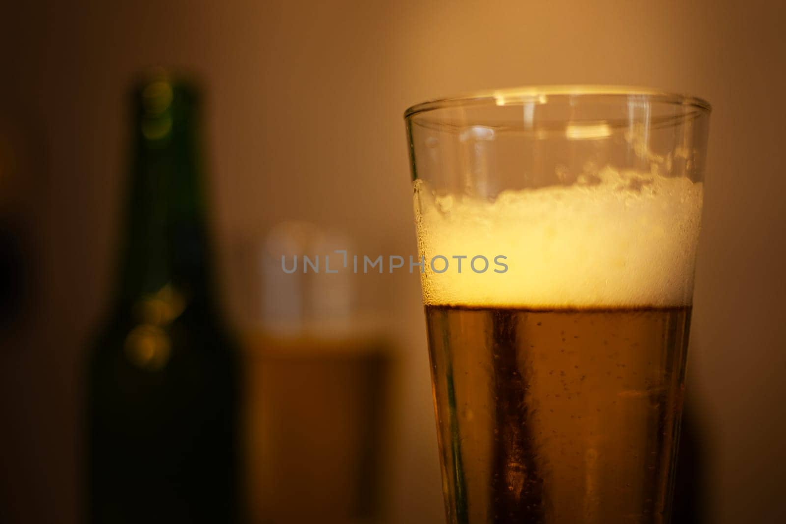 Glass of chilled beer on table and blurred background. 