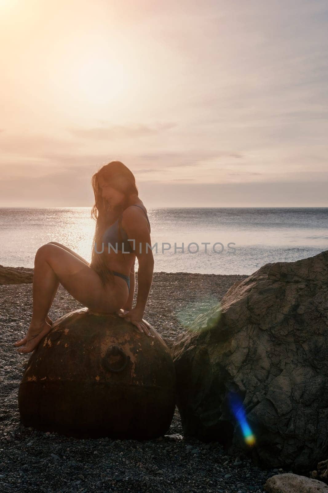 Woman travel sea. Young Happy woman in a long red dress posing on a beach near the sea on background of volcanic rocks, like in Iceland, sharing travel adventure journey