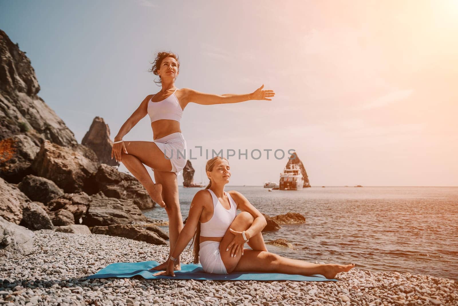 Woman sea yoga. Back view of free calm happy satisfied woman with long hair standing on top rock with yoga position against of sky by the sea. Healthy lifestyle outdoors in nature, fitness concept.