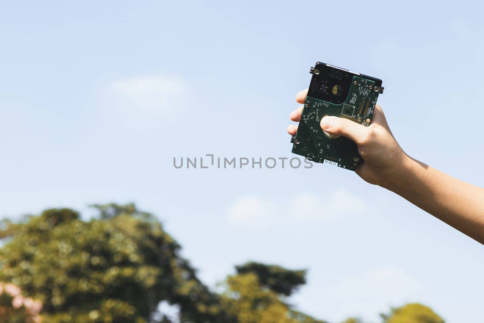 Recyclable electric waste held in hand up on sky background. Hand holding electronic trash for recycle reduce and reuse concept to promote clean environment with recycling management. Gyre