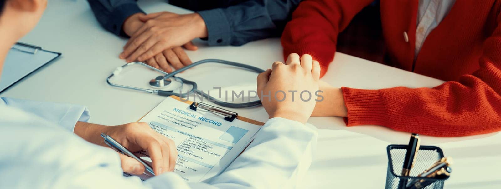 Couple attend fertility consultation with gynecologist at hospital as part family planning care for pregnancy. Loving husband and wife support each other through the doctor appointment. Panorama Rigid