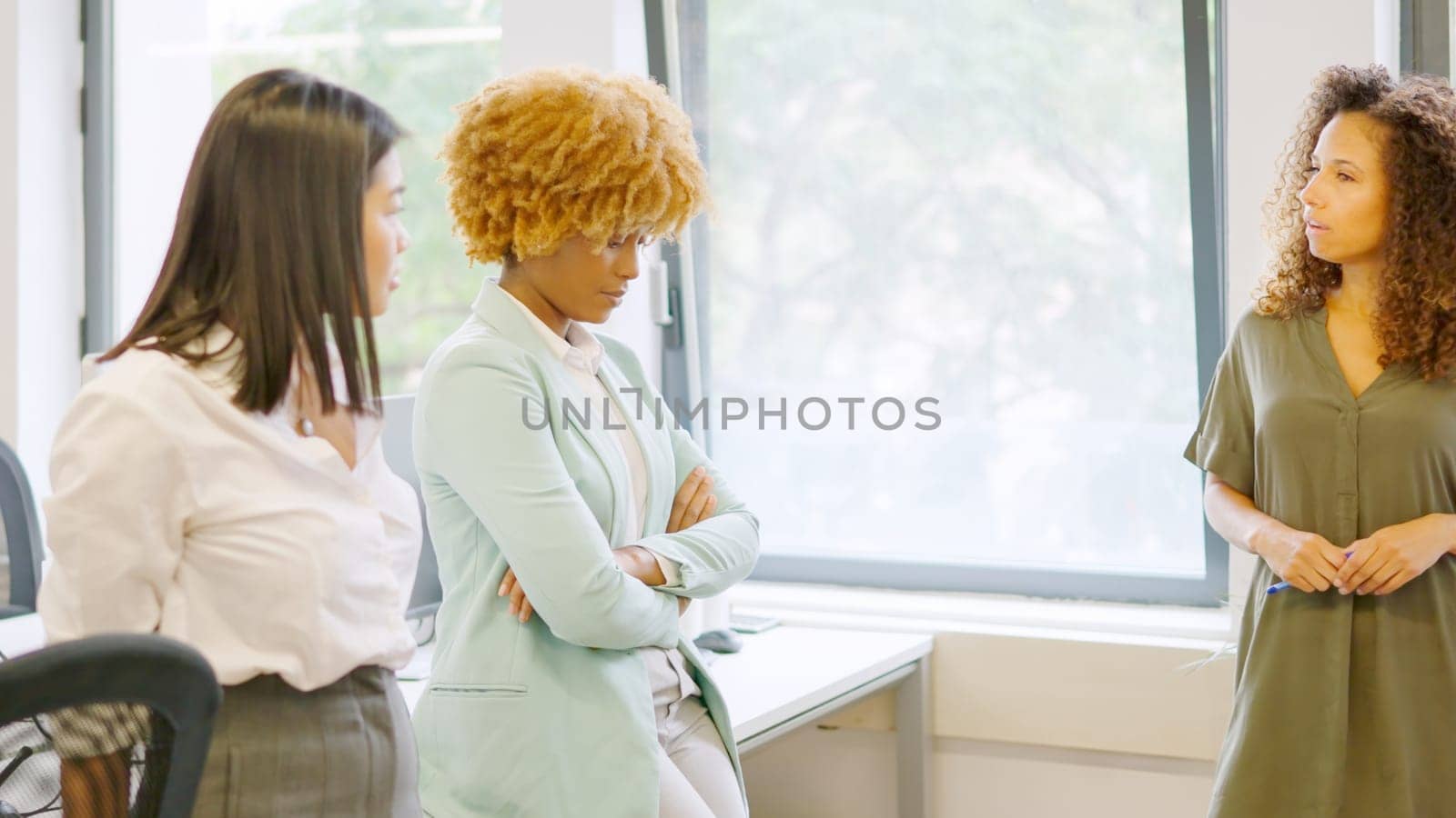 Woman scolding multi-ethnic colleagues in the office of a coworking