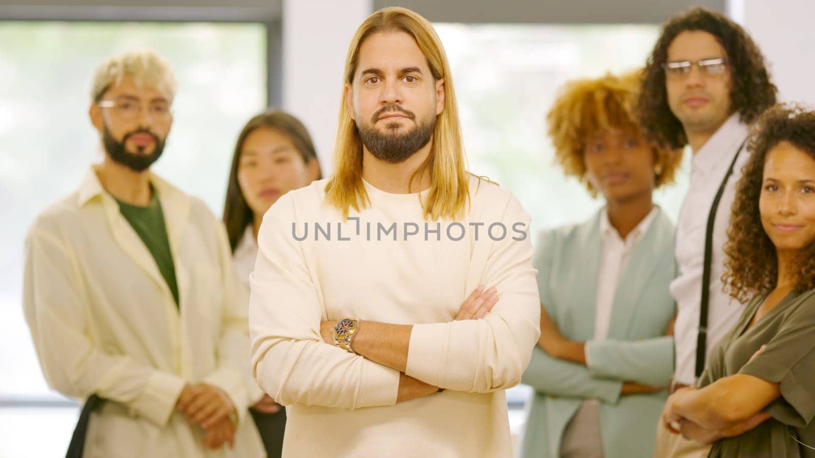 Man leading a group of coworkers standing proud in the office