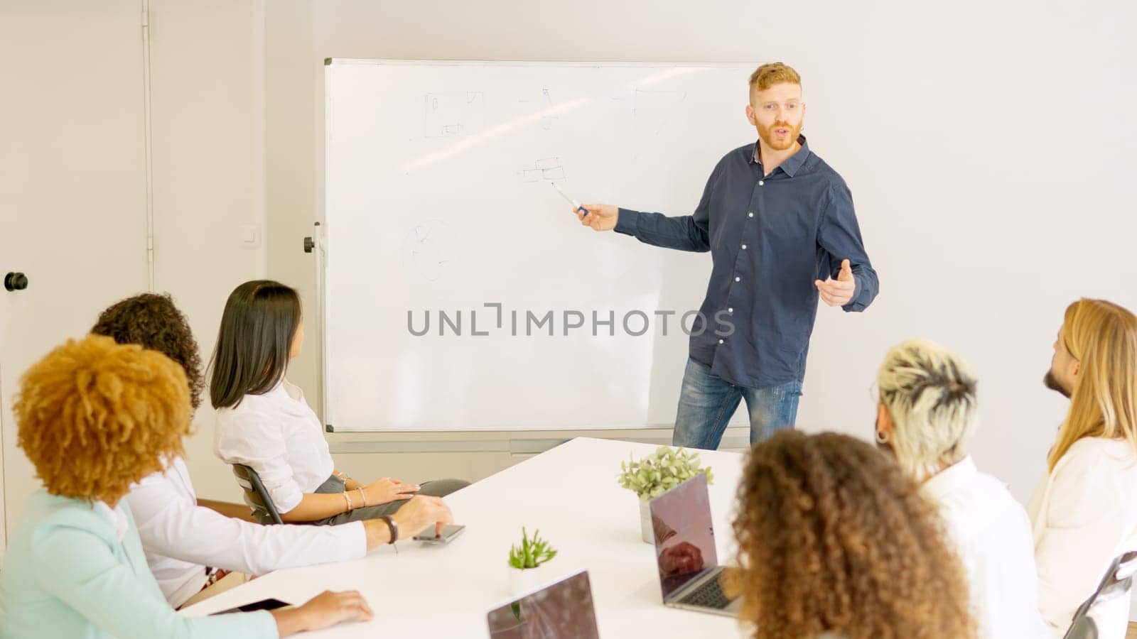 Picture of a man talking during a business meeting using a white board