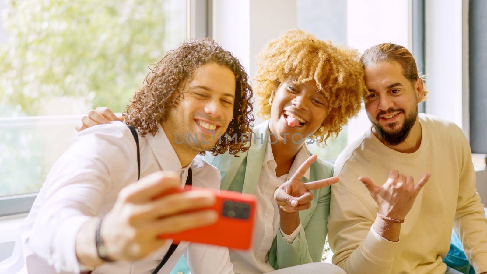 Multi-ethnic smiling coworkers taking a selfie during a work break