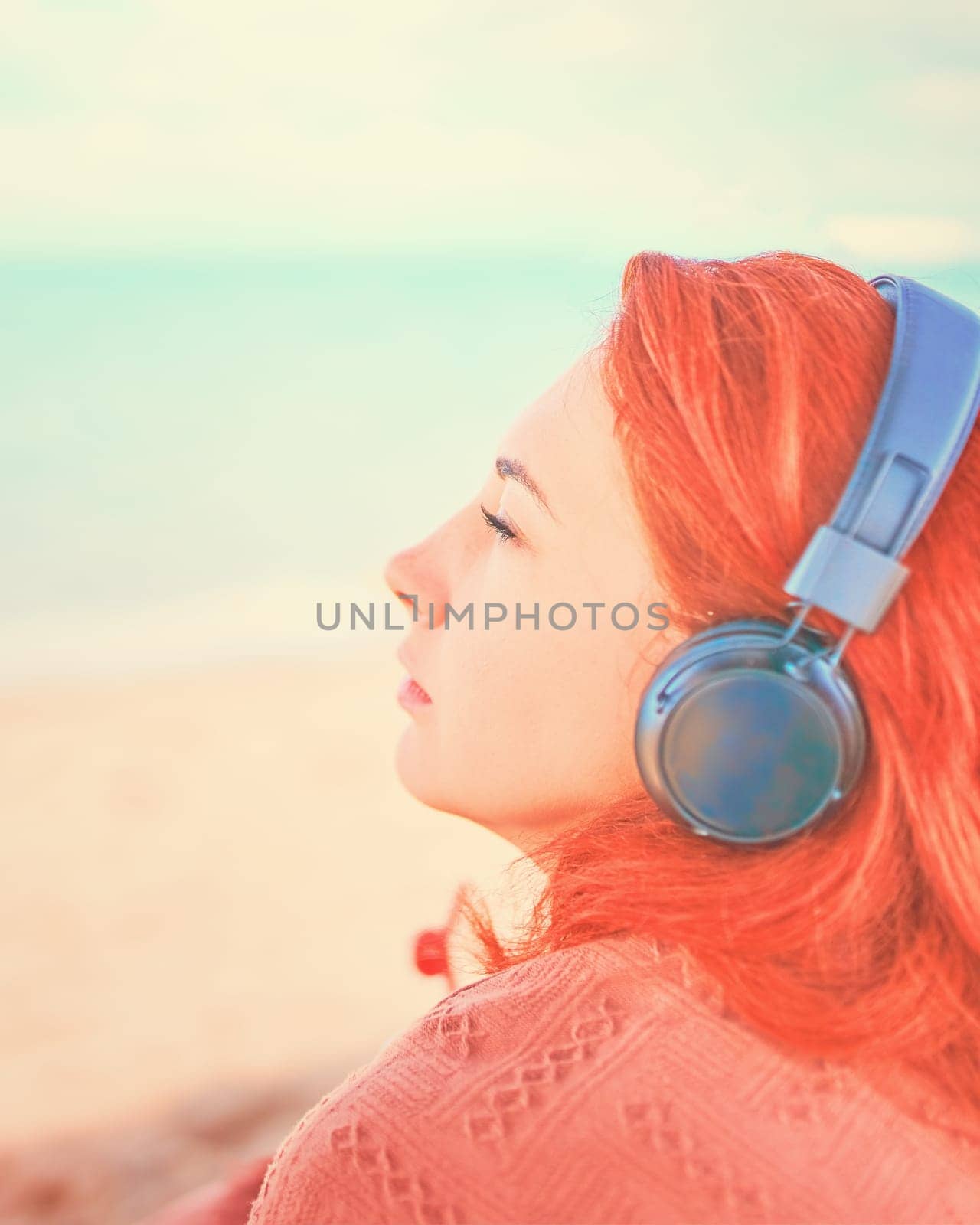 Beautiful woman listening to music on the beach. Sexy woman listening to the music on the beach.