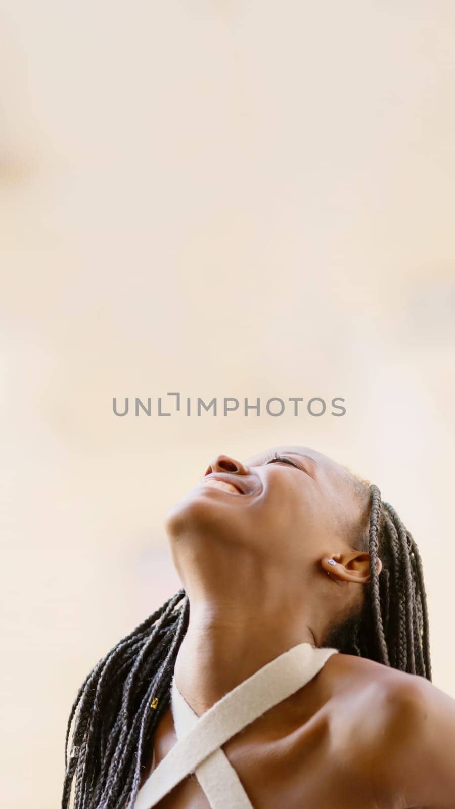 Young black woman looking up smiling, with copy space