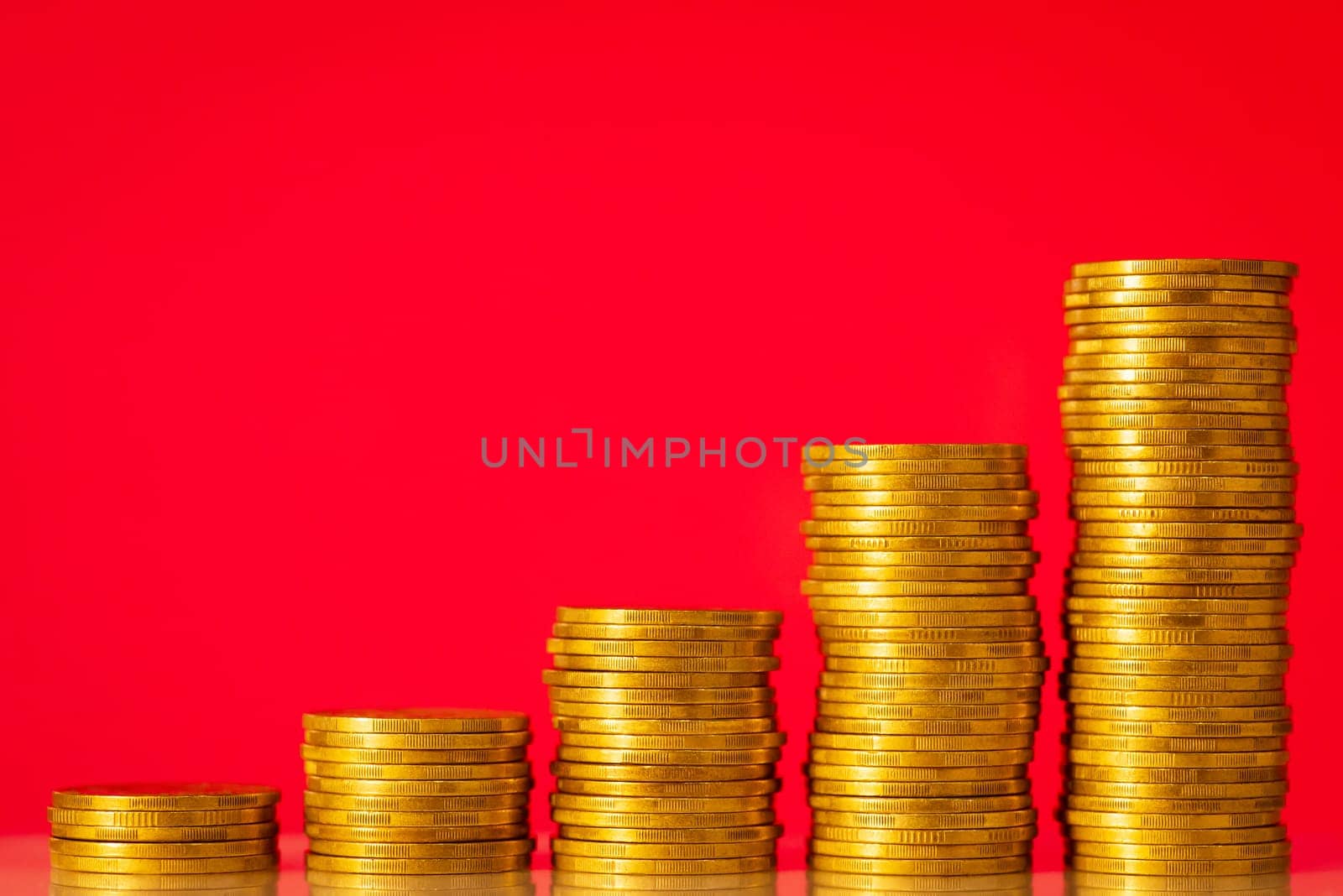 Five stacks of gold coins against red background forming rising chart by VitaliiPetrushenko