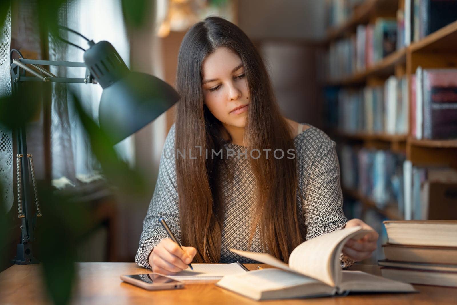 Female student working in library by VitaliiPetrushenko