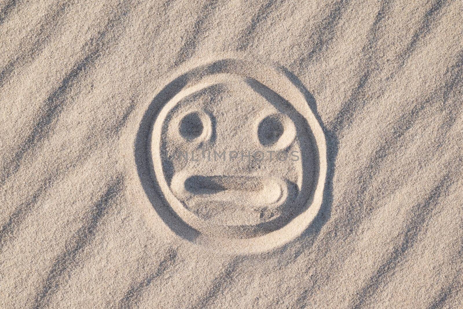 Sad and bewildered smile on sand by VitaliiPetrushenko
