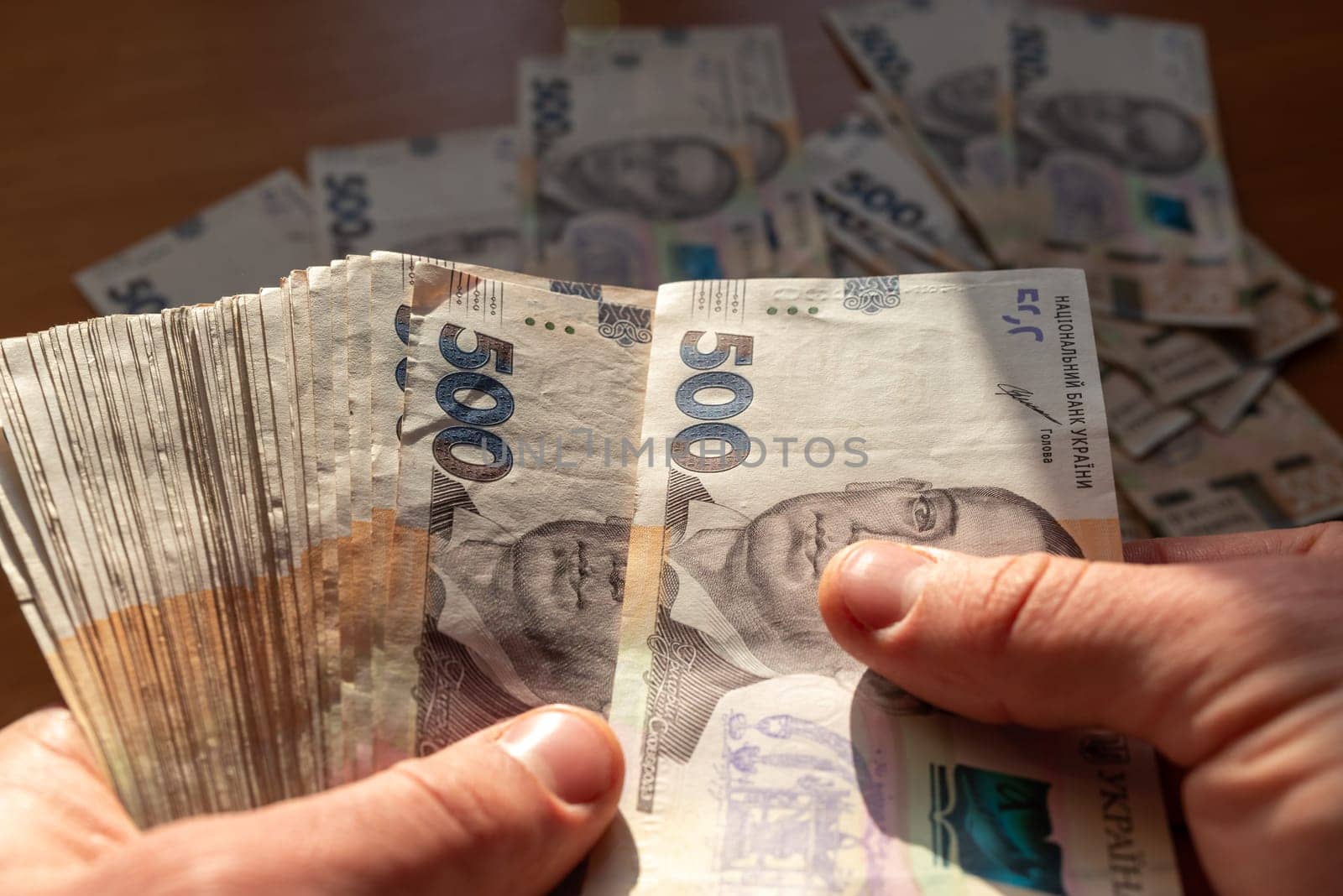 Man counting ukrainian hryvnia money by VitaliiPetrushenko