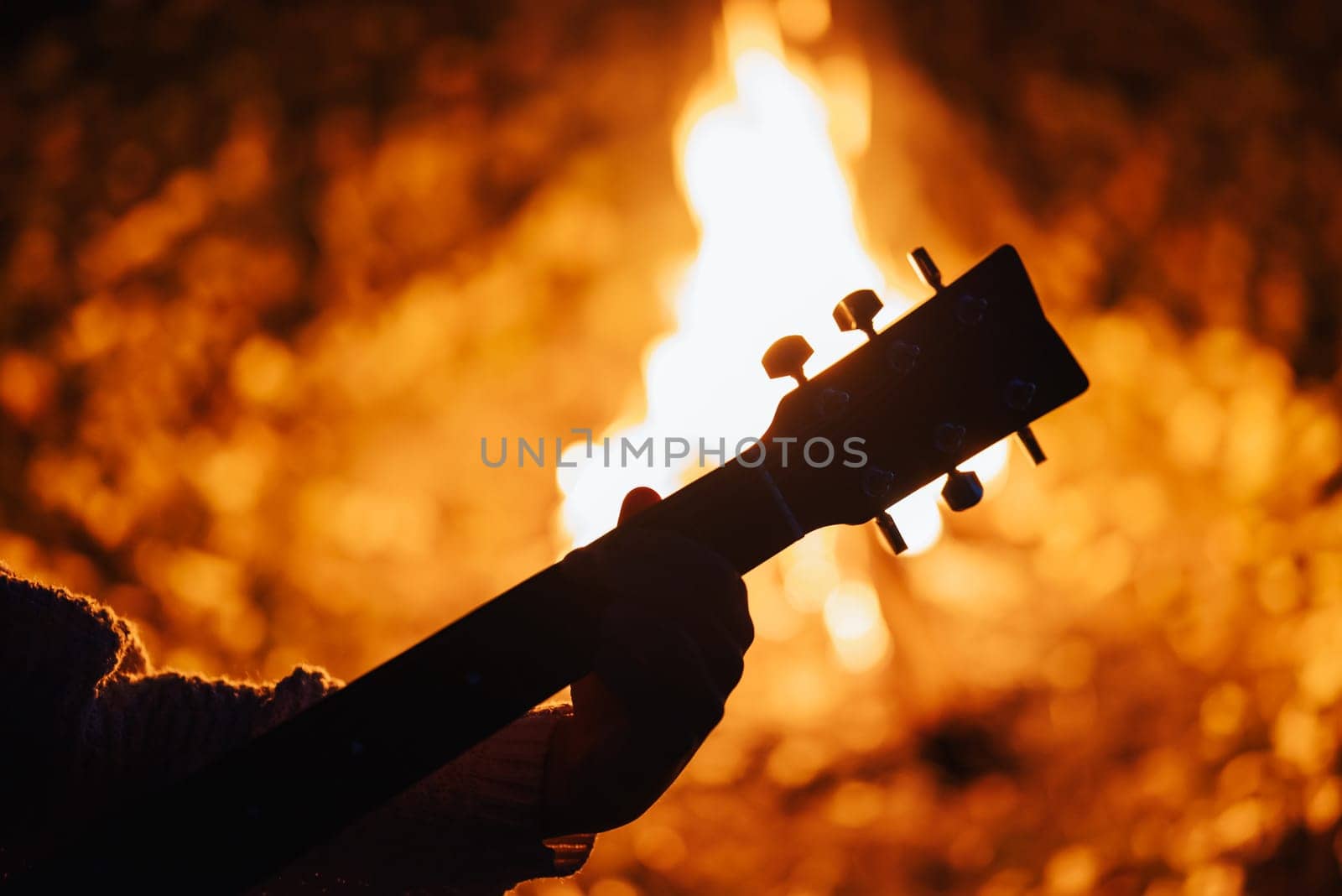 Spending time with friends near bonfire, play the guitar