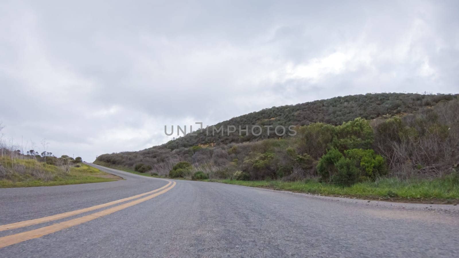 In this serene winter scene, a vehicle carefully makes its way along Los Osos Valley Road and Pecho Valley Road within Montana de Oro State Park.