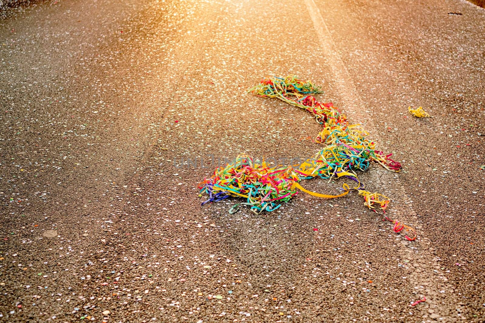 Close up colorful confetti and streamers at the street after Carnival parade