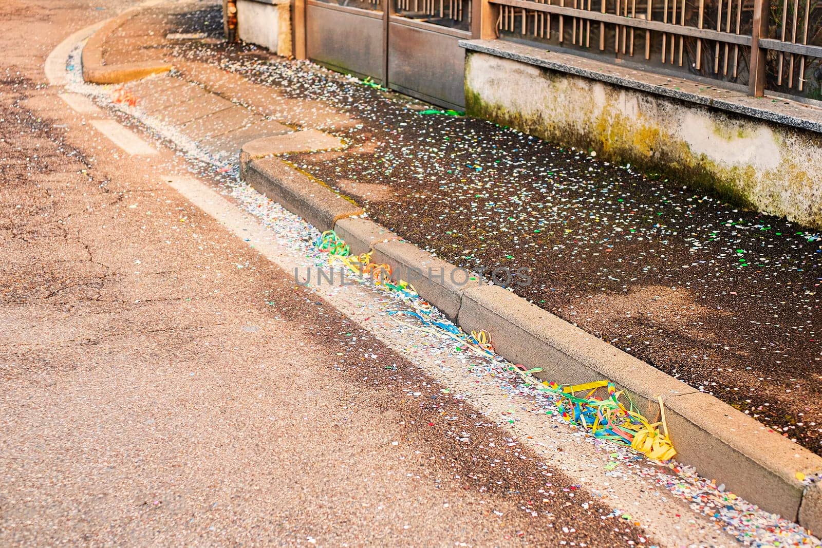 Close up colorful confetti and streamers at the street after Carnival parade