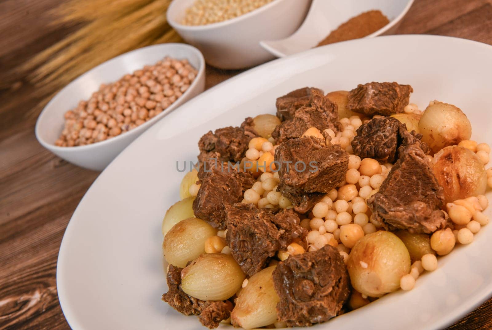 Moughrabieh is a popular dish in the Lebanese cuisine, LEBANESE RECIPE FOR MOUGHRABIEH WITH BEEF AND SMALL ONIONS, SEMOLINA PEARLS AND CHICKPEAS. High quality photo