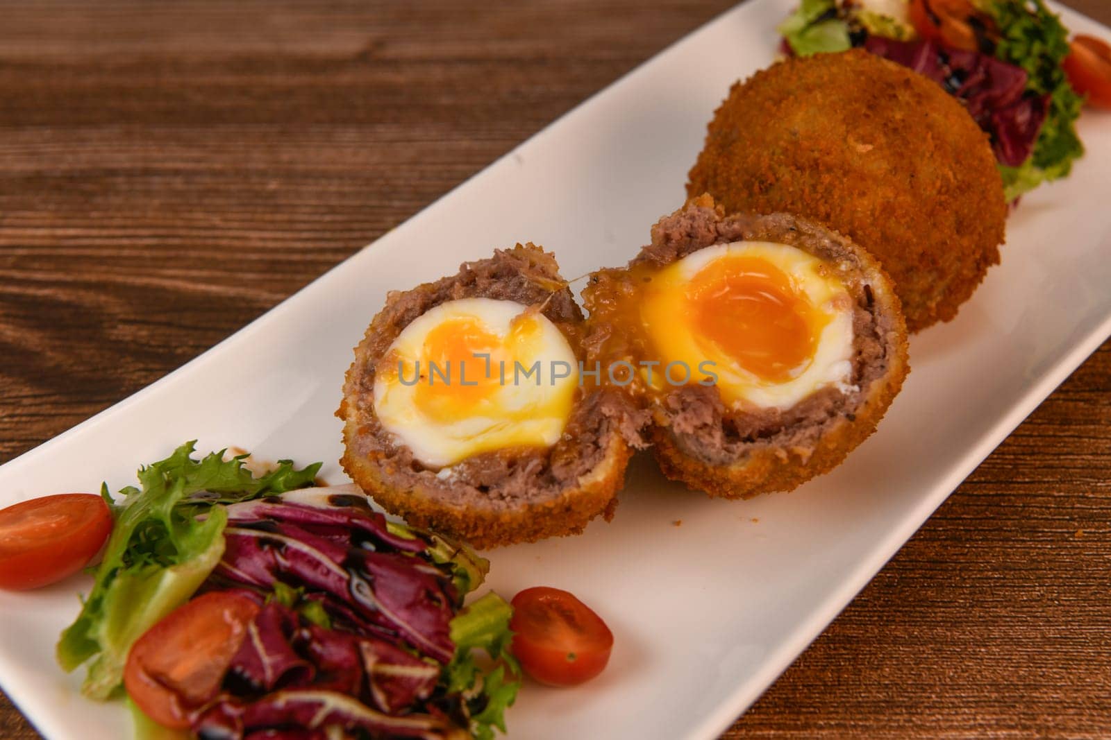 RECIPE FOR BREADED BEEF MEATBALLS STUFFED WITH A SOFT BOILED EGG. High quality photo