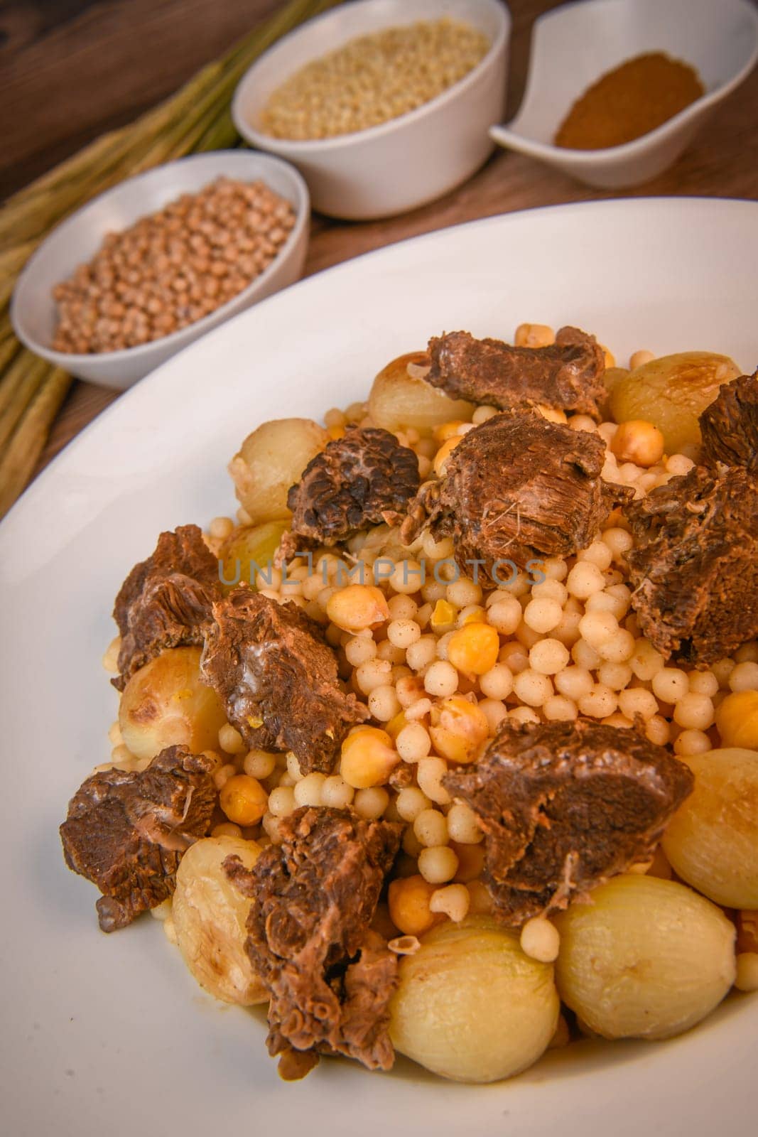 Moughrabieh is a popular dish in the Lebanese cuisine, LEBANESE RECIPE FOR MOUGHRABIEH WITH BEEF AND SMALL ONIONS, SEMOLINA PEARLS AND CHICKPEAS. High quality photo