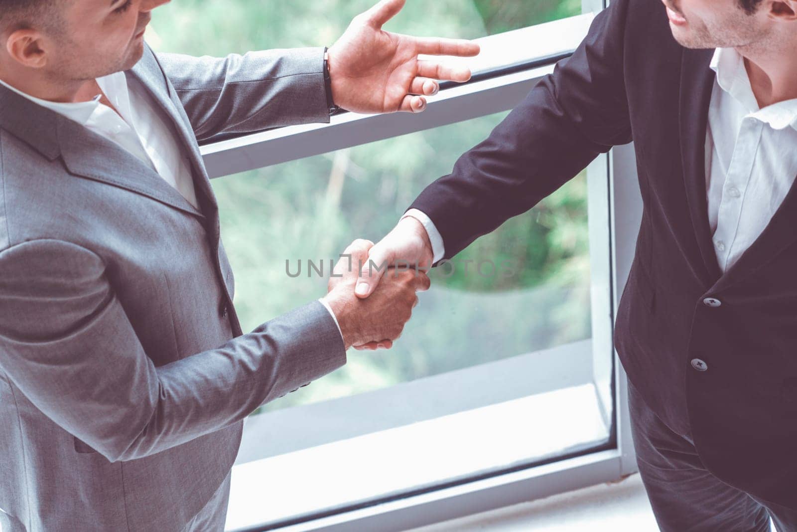 Businessmen handshake business deal in office. uds by biancoblue