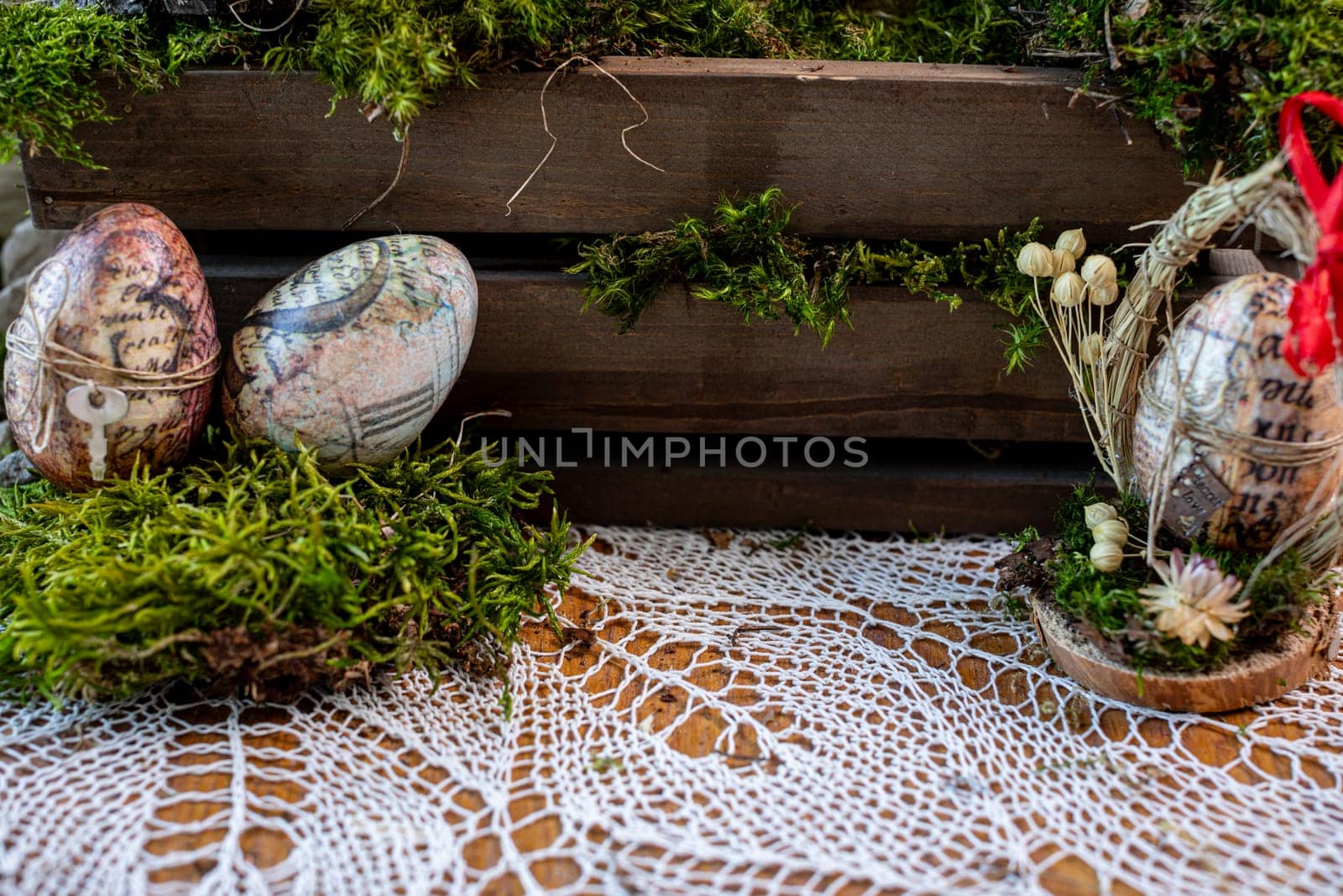 Embark on a visual journey through this captivating Easter composition, where lush green moss serves as a canvas for two intricately decorated eggs adorned with letters and numbers.