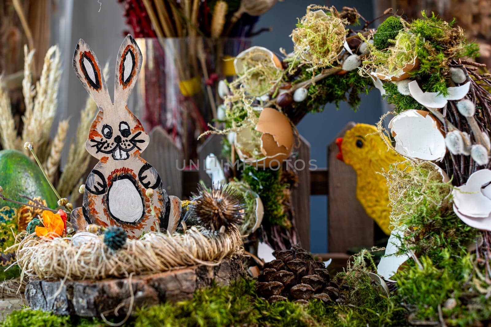 In this captivating Easter scene, a wooden crate adorned with a bird's nest houses a charming wooden rabbit figure, meticulously crafted and painted to resemble a lifelike appearance.