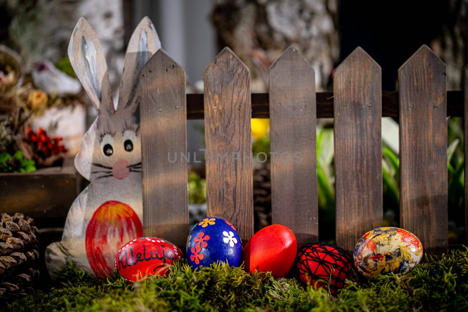 In this whimsical Easter scene, colorful eggs adorned with delicate patterns rest gracefully on a bed of lush green moss, with one egg bearing the joyful inscription alleluja.