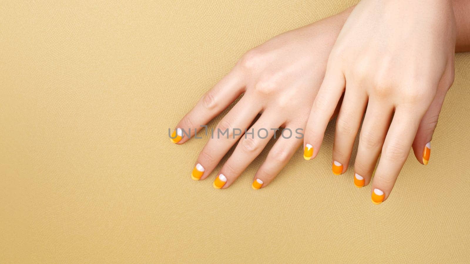 Beautiful Female Hands with bright orange Manicure like Candy Corn. Manicured Nails with Yellow Gel Polish. Halloween Style by MarinaFrost