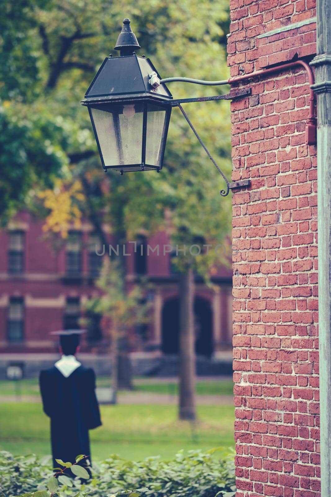 A Student In Formal Gown And Mortarboard In A Courtyard At A Prestigious New England University