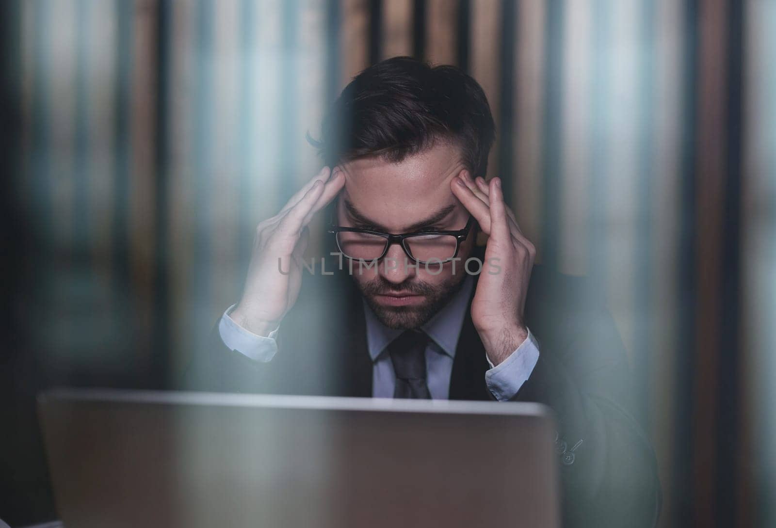 Worried businessman holding his head in his hands
