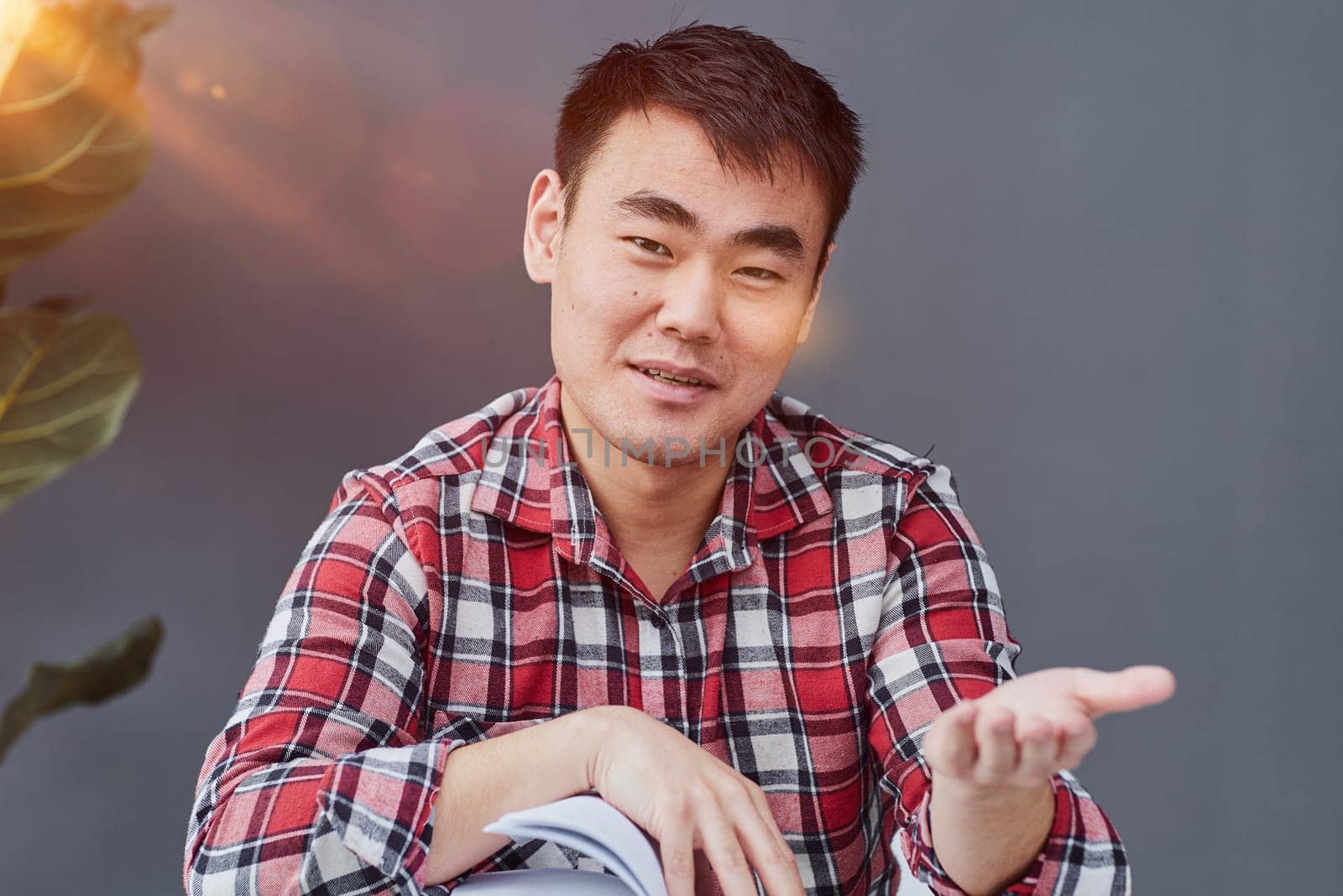 Handsome man propping his chin with his hands while sitting at the table in the office