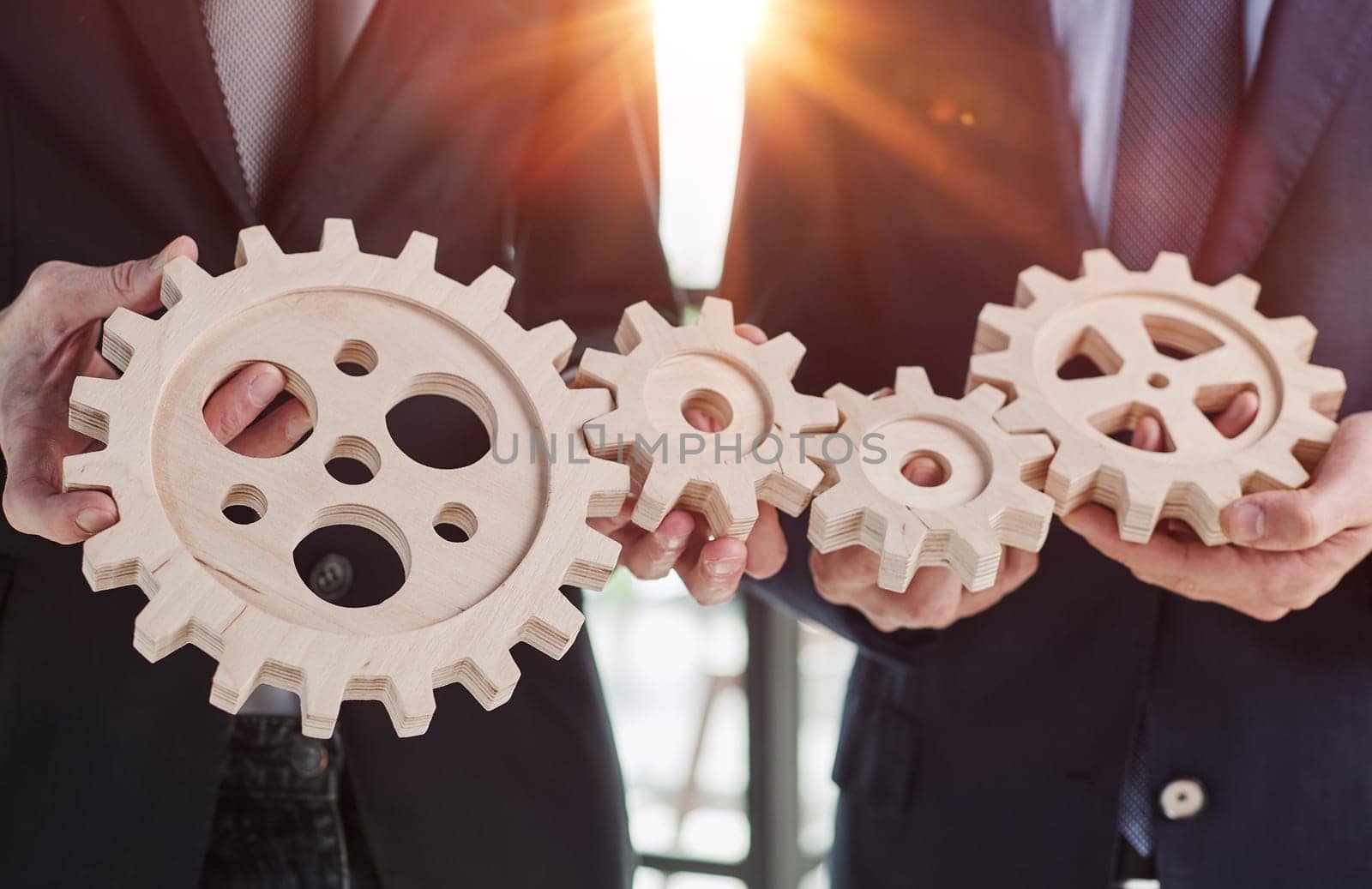 Close up hands holding round wooden figurines on the background of office worker. by Prosto