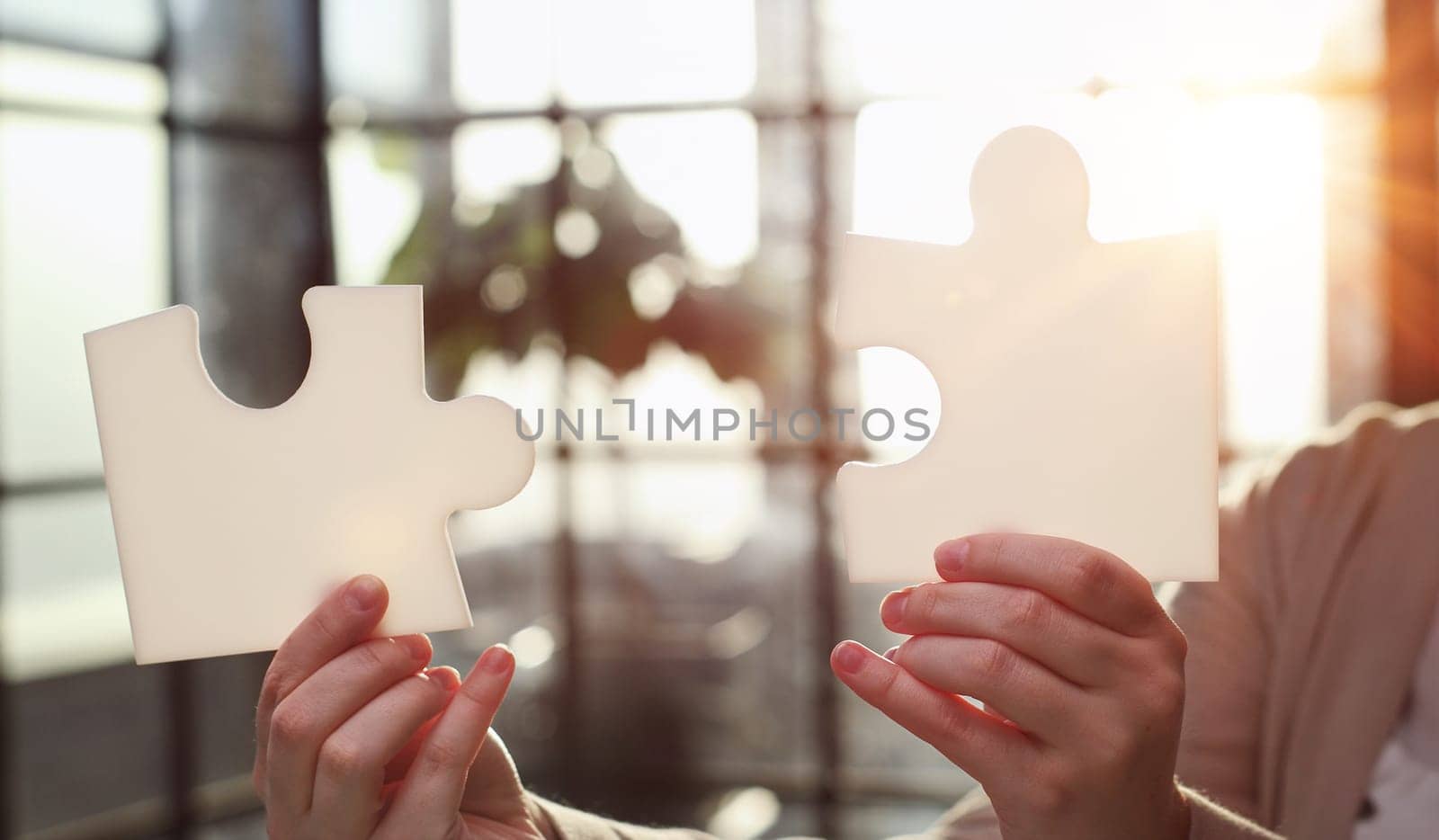 Business Woman holding two blank white puzzle pieces in his hands conceptual of solving a problem