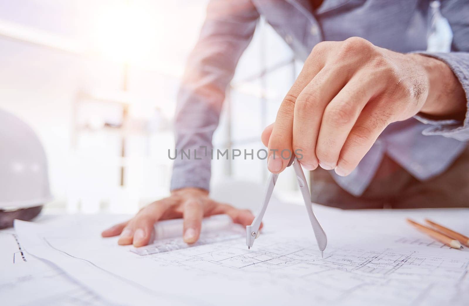 Architect working on drawing table in office by Prosto