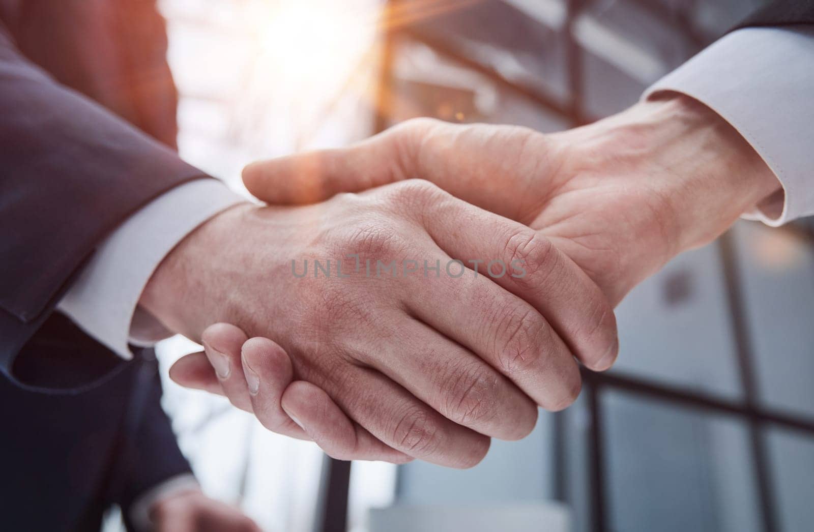Handshake of two businessmen in a conference room, close-up