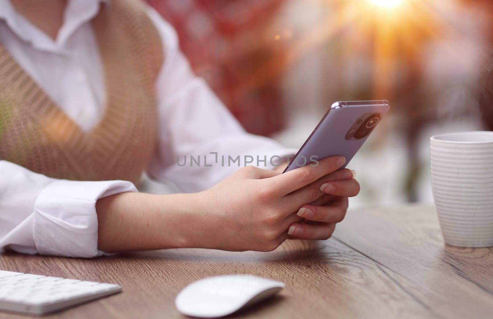 young woman in modern office browsing smartphone by Prosto