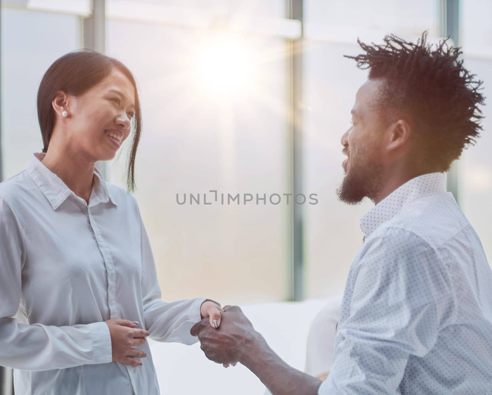 Handshake between business man and woman indoors.