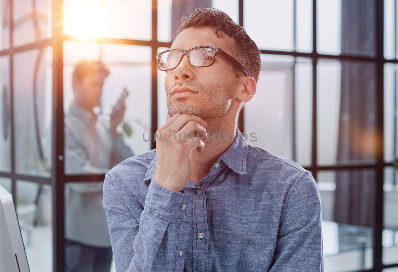 Close-up portrait of a serious and thoughtful businessman in glasses