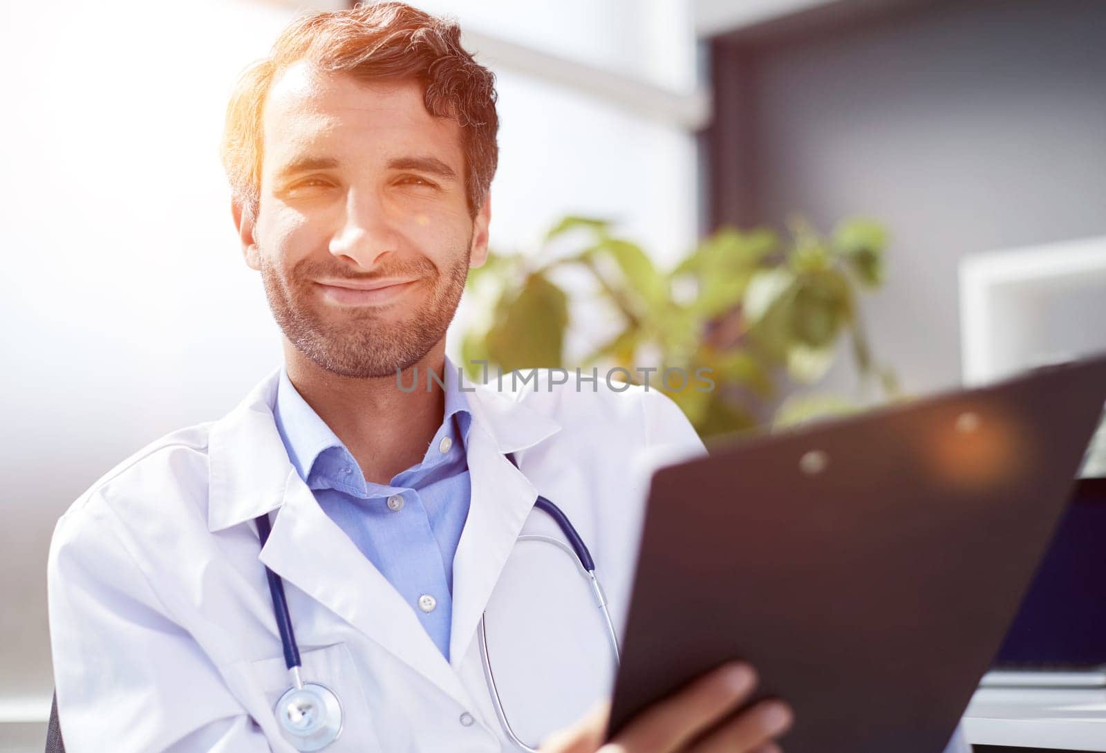 A male doctor in a white coat looks at the medical history.