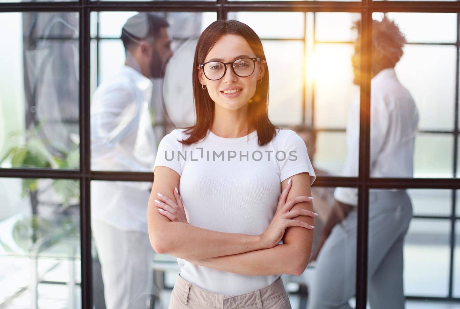 business woman with her staff in background at office by Prosto