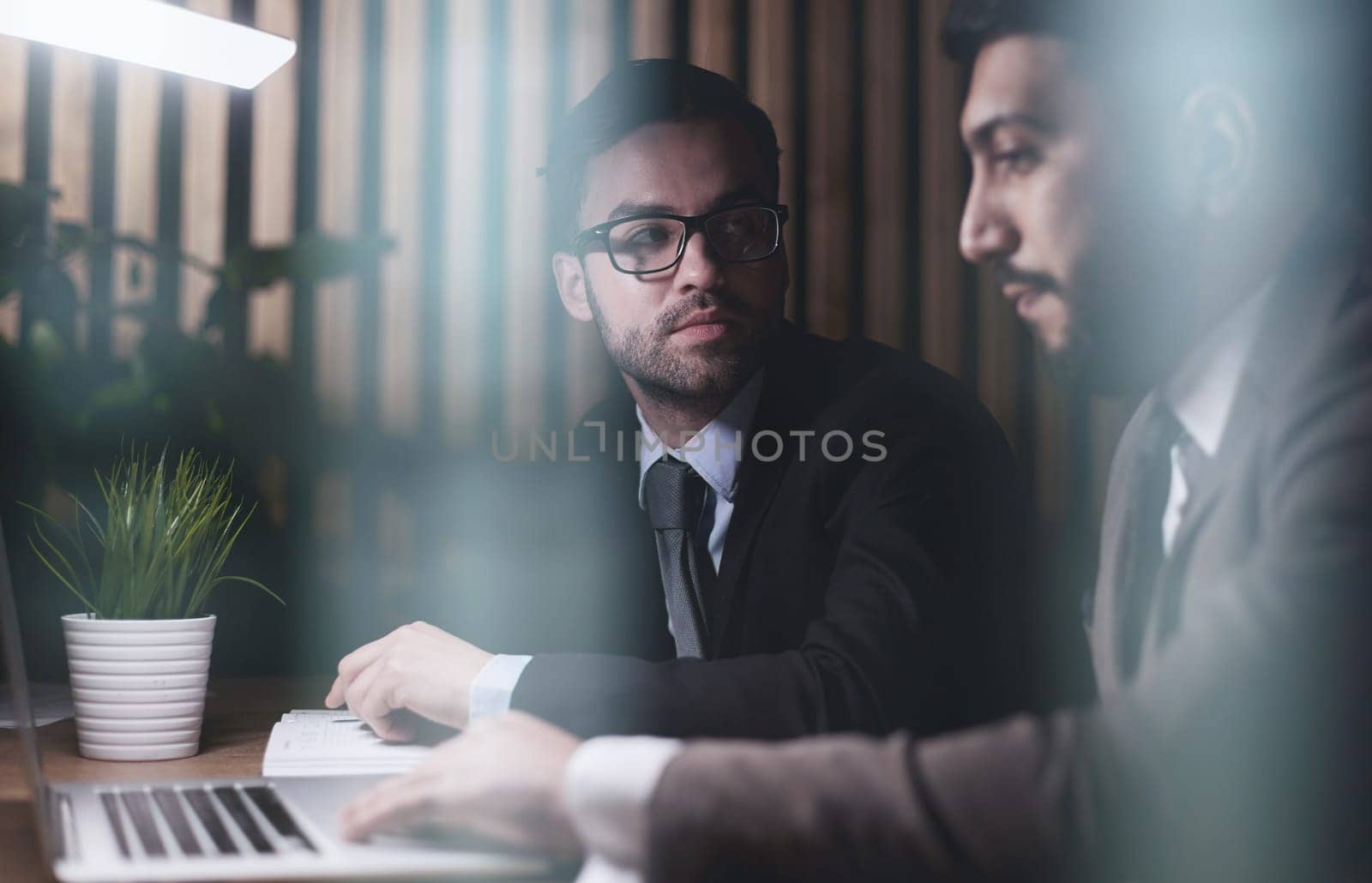 Two middle-aged business workers work at a desk in an office. by Prosto