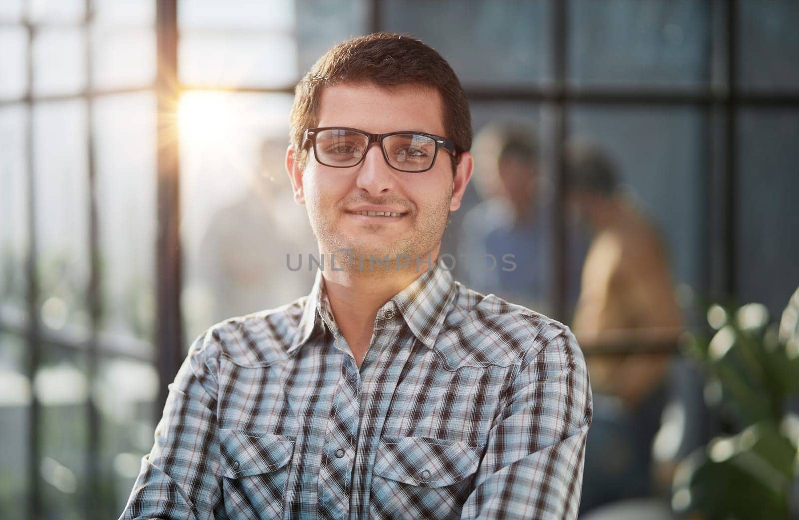 Handsome businessman standing with crossed arms and looking camera