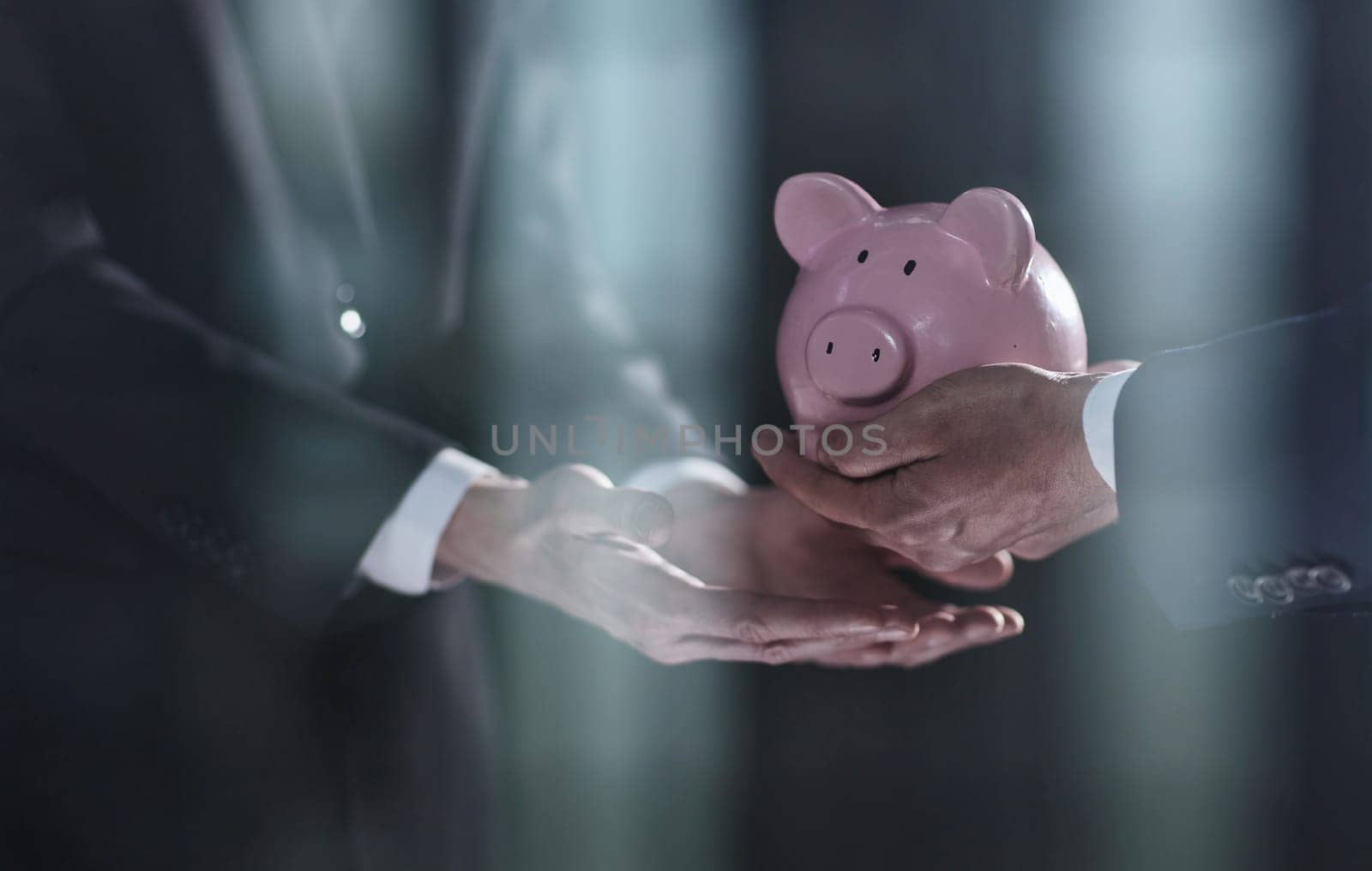 A businessman gives you a piggy bank isolated on a black background. banking