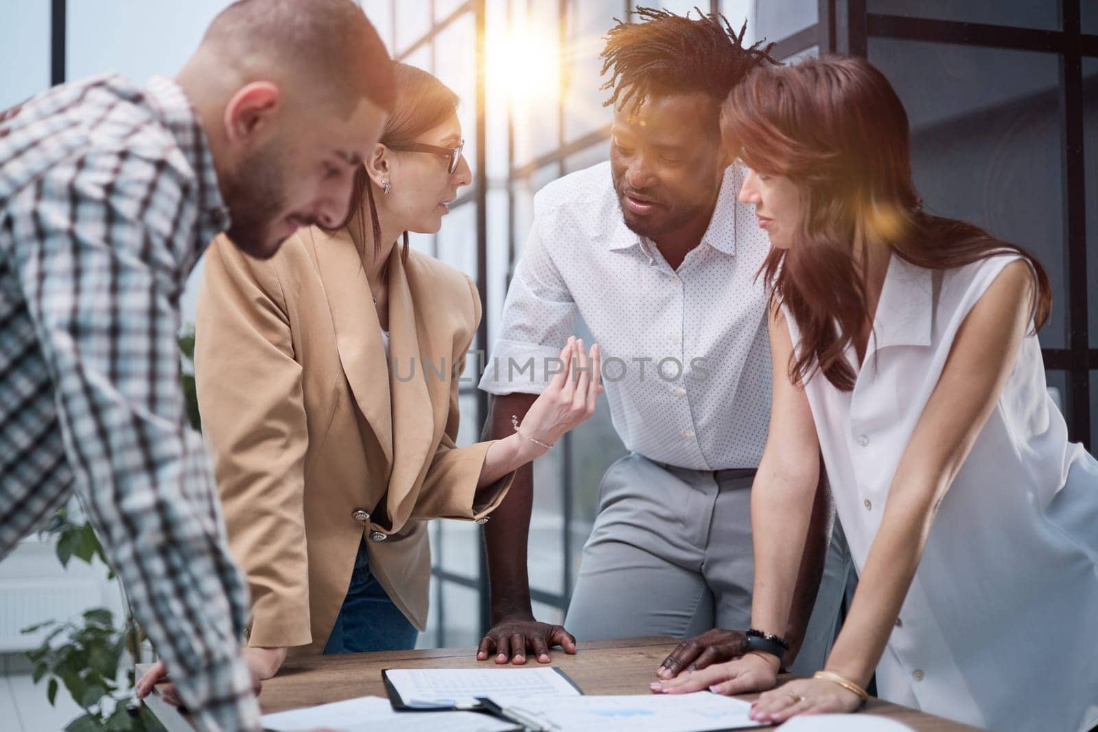 Business team discussing financial charts while standing at the table in the office